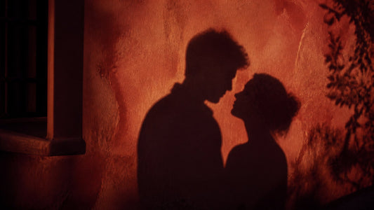 Silhouette of a couple cast on a warm terracotta wall, cover image for anal sex positions guide