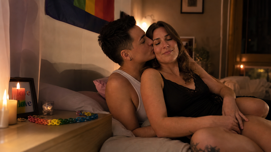 Couple celebrating Pride Month at home with candles and rainbow chain
