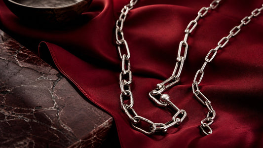 Hand-welded silver slip-chain necklaces on red silk