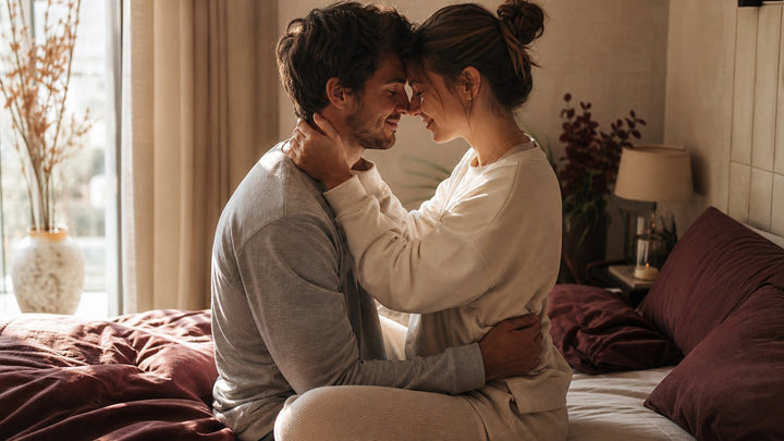 Couple embracing in a warm bedroom, triceratops sex position guide