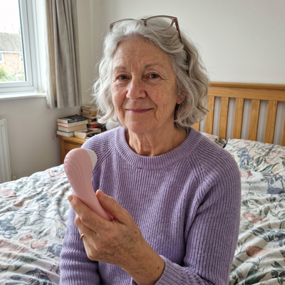 A woman smiling with the WildNightX Bloom in bed